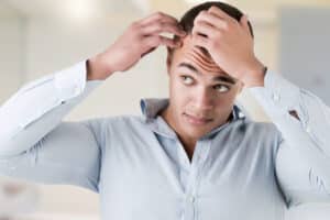 A man looking at his hairline